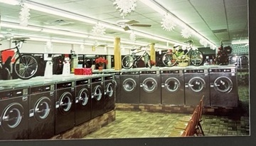 World O' Suds Coin Laundry, 430 E Main St Apopka FL — vintage photo of a long row of washers with Christmas snowflake ceiling decorations and bicycles displayed overhead