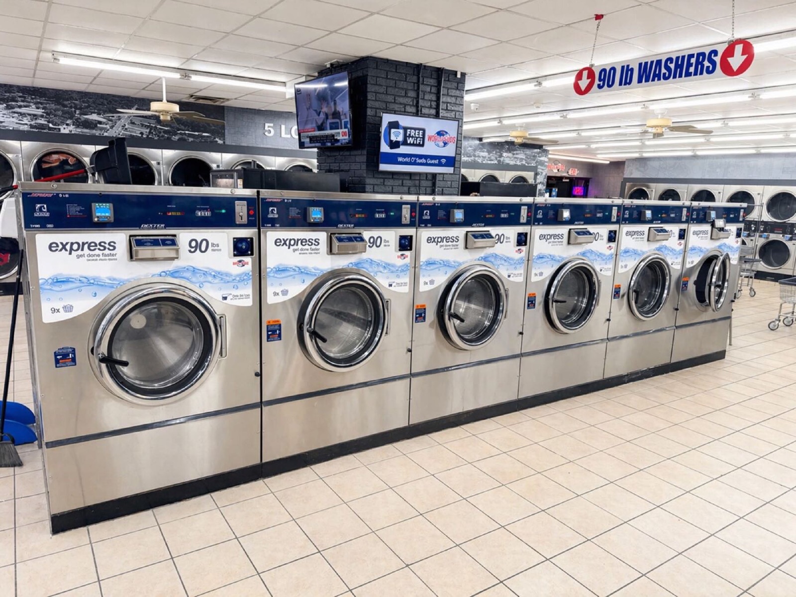 World O' Suds Coin Laundry, 430 E Main St Apopka FL — six Dexter Express 90 lb washers beneath the red 90 lb WASHERS overhead sign in the commercial laundry facility