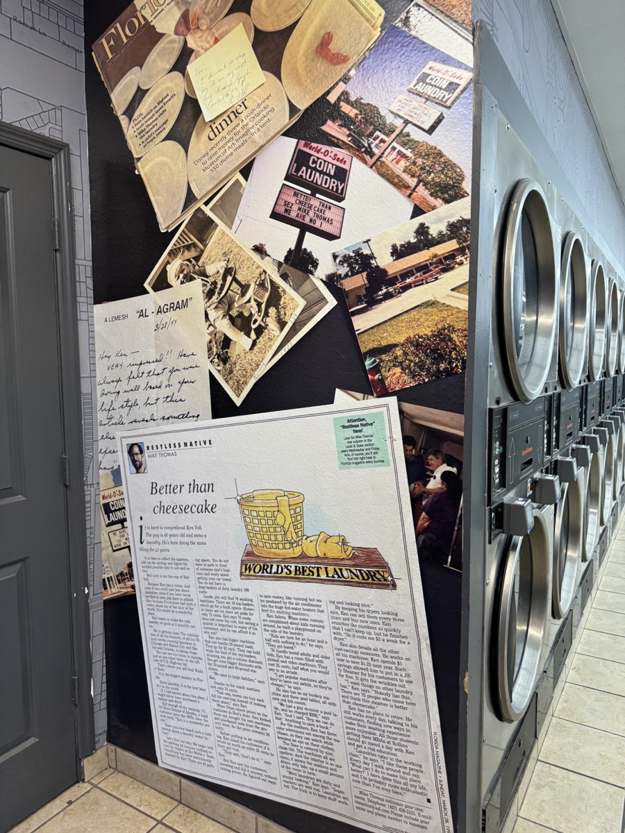 World O' Suds Coin Laundry, 430 E Main St Apopka FL — in-store heritage collage wall displaying the Better Than Cheesecake Florida Magazine article, vintage photographs, and handwritten notes from the store's history